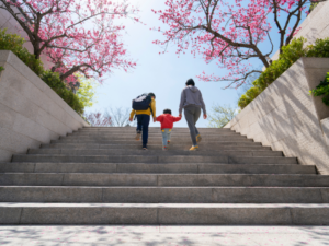 Parent walks with two kids up steps