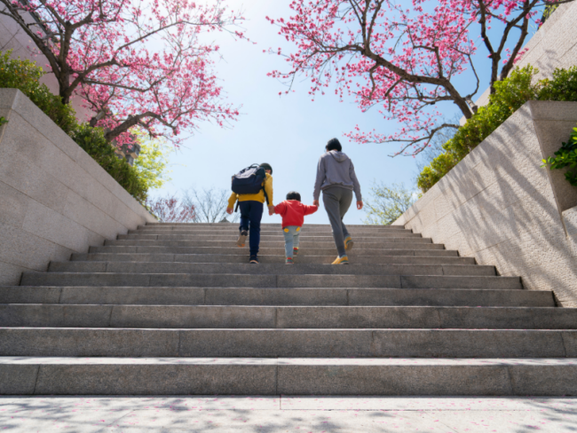 Parent walks with two kids up steps
