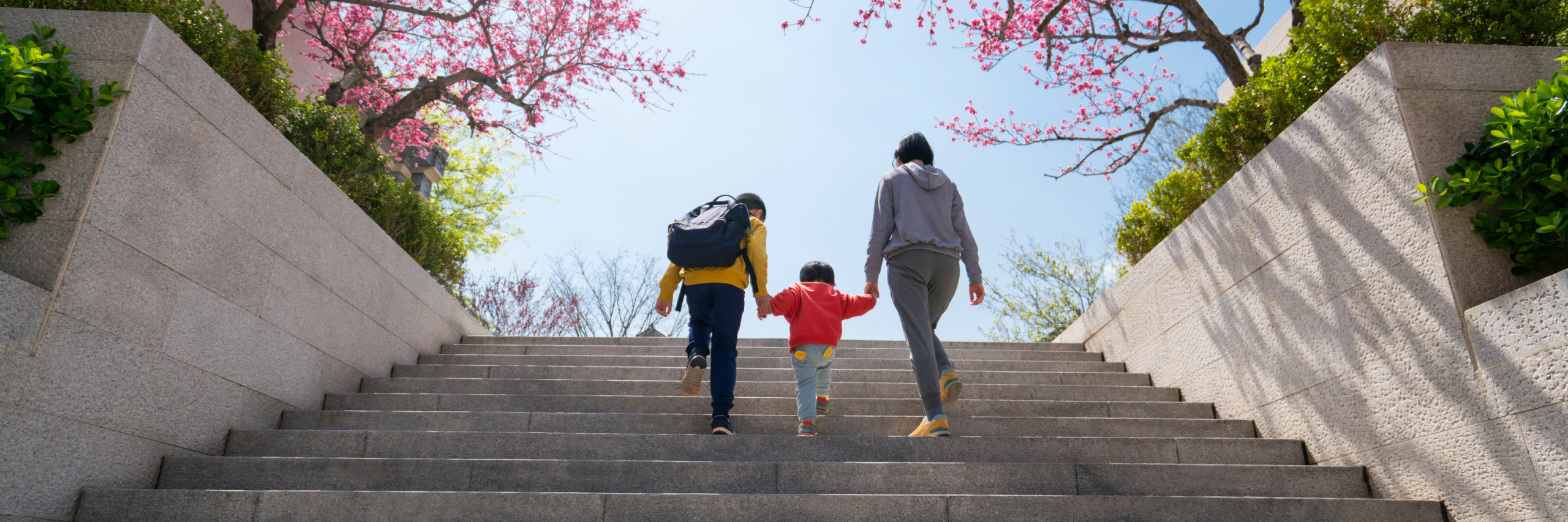 Parent walks with two kids up steps