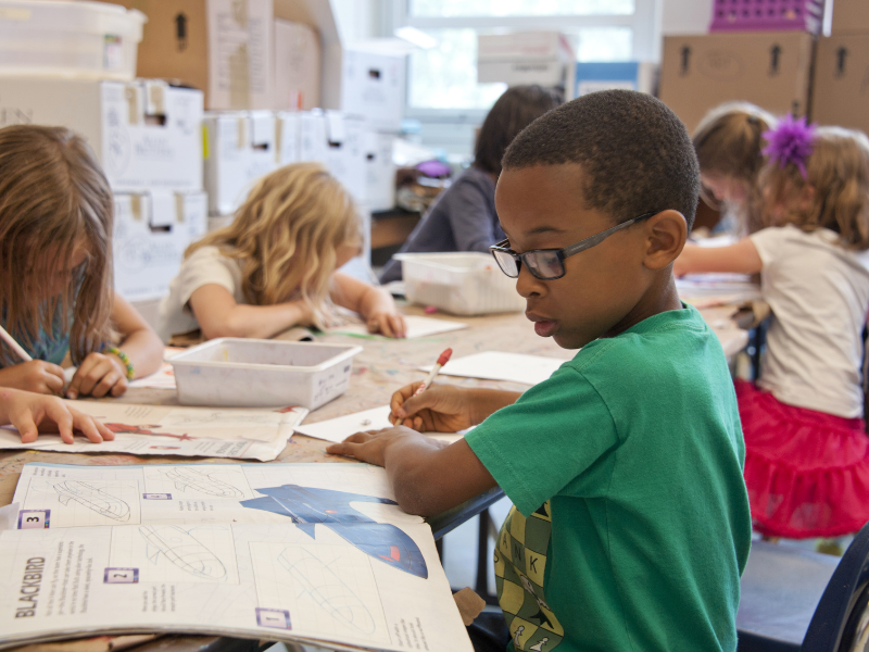 A child looks at his homework in a classroom
