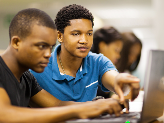 Two students working together in a library