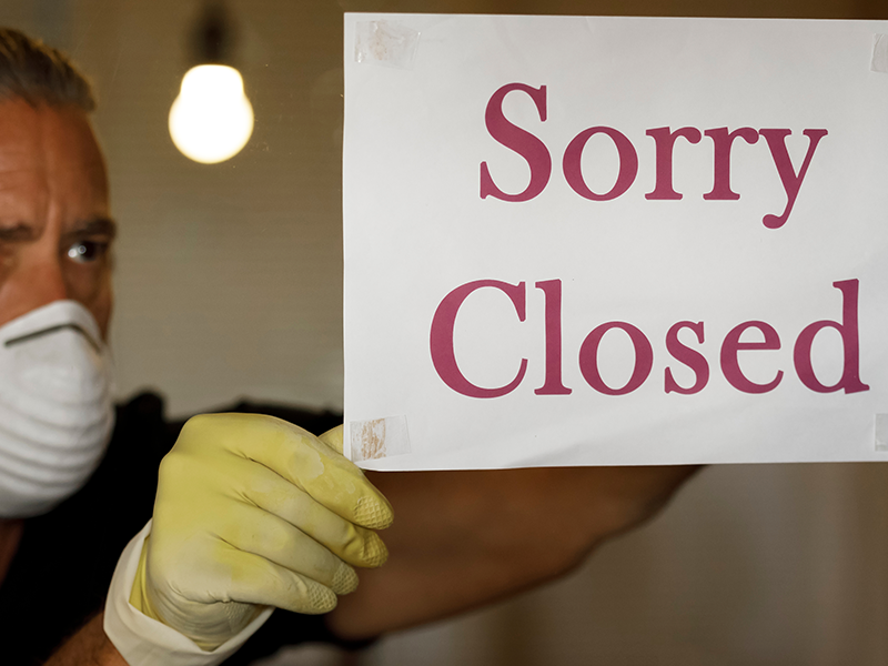 Man holding up a sorry closed sign