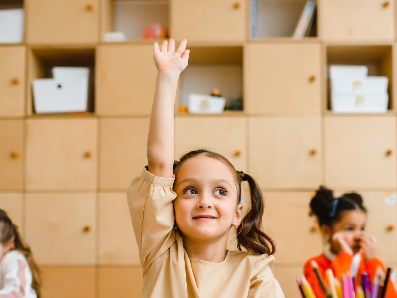 Child raising hand in classroom