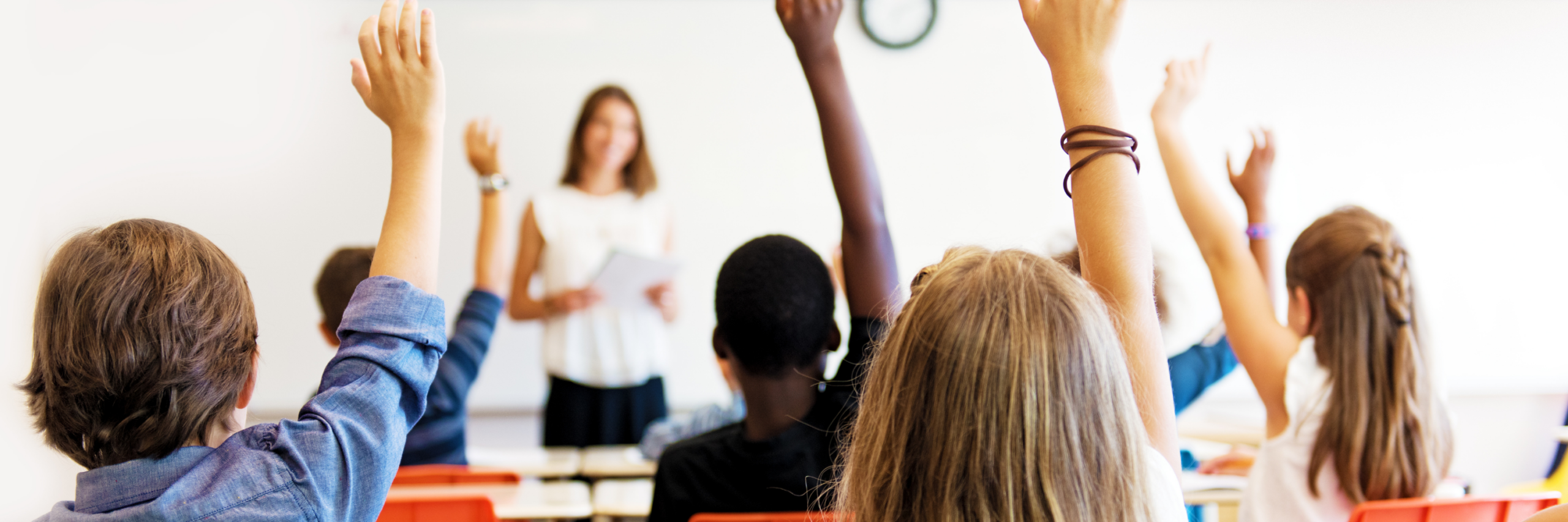 Children raising hand in classroom