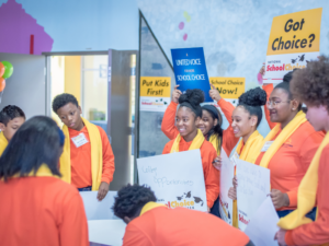 A diverse group of students holding a 'National School Choice Week' banner, representing inclusivity in education.