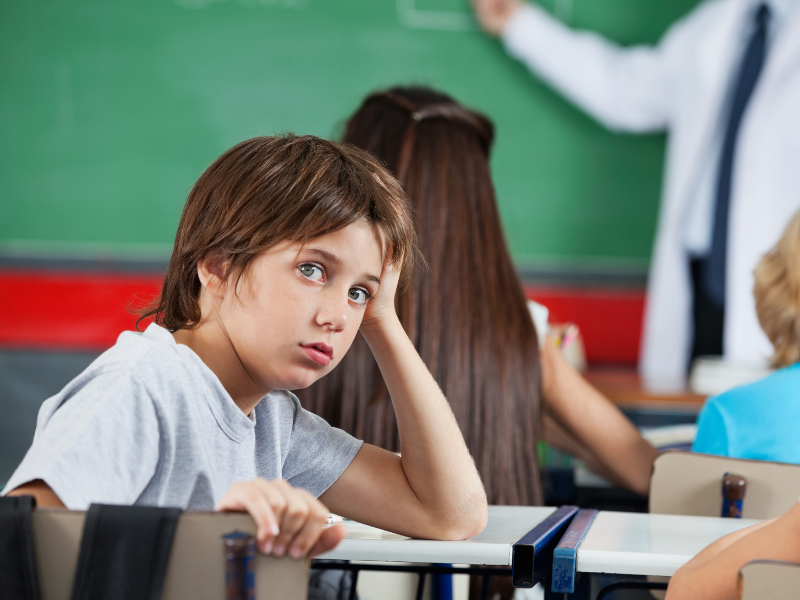 unhappy boy in classroom