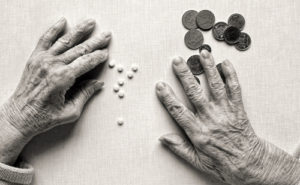 Woman's hands with pills and money in black and white
