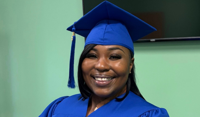 Ayonia smiles for the camera in her graduation cap and gown