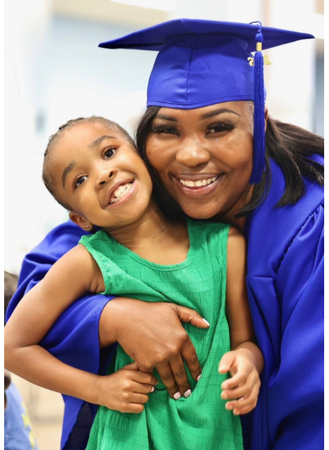 Ayonia, in her cap and gown, has her arm around her daughter, Dior. Both smile for the camera.